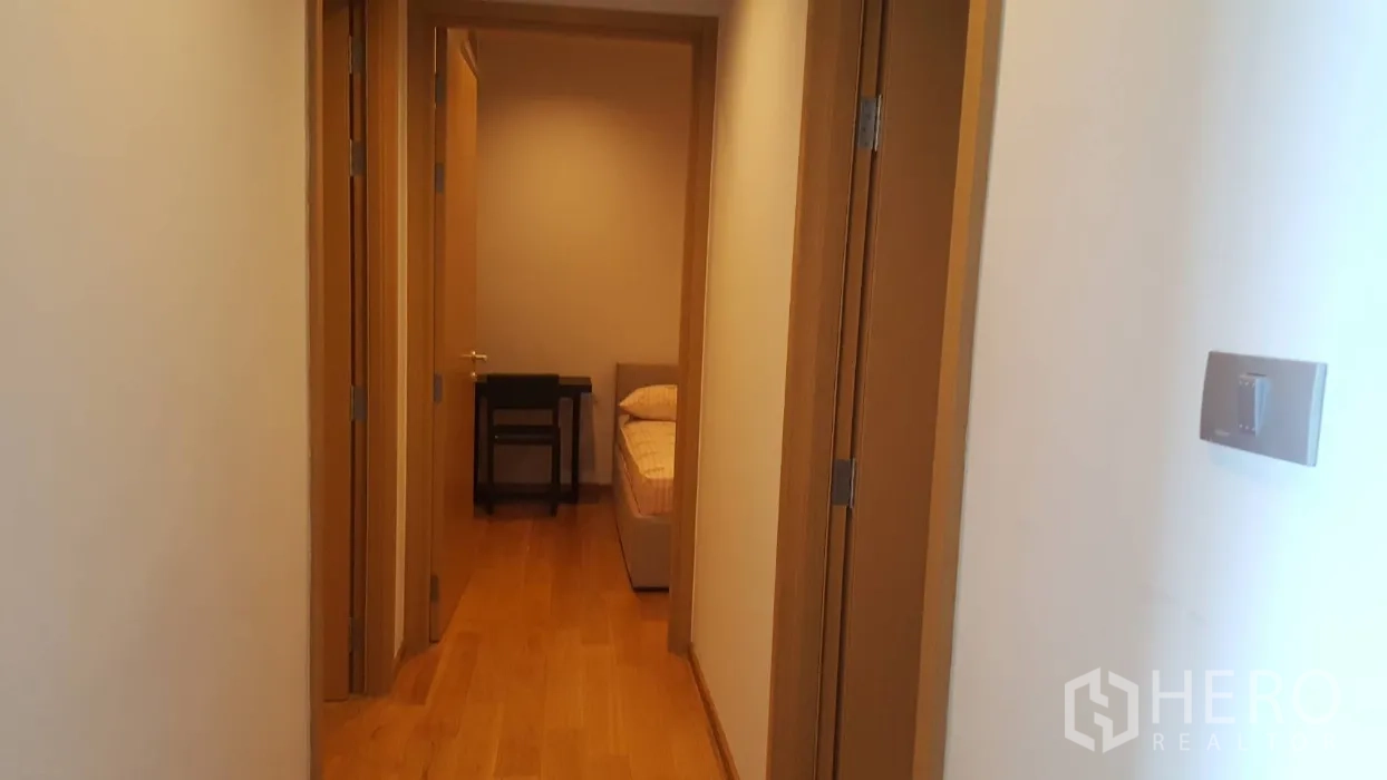 คอนโด ให้เช่าในWatthana, Bangkok - โถงทางเดินสว่าง พื้นไม้ ประตูไม้ เปิดสู่พื้นที่ห้องนอนในคอนโดสมัยใหม่