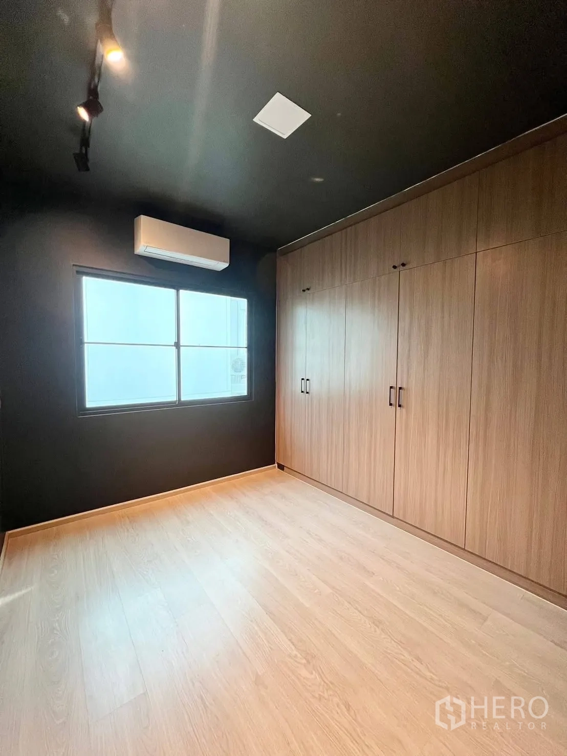联排别墅 for rent in Bang Phli, Samut Prakan - 卧室带深色天花、大面积木质衣柜、窗户与空调。