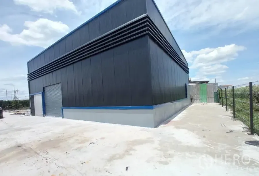 คลังสินค้า ให้เช่าในSaphan Sung, Bangkok - มุมมองด้านข้างและหลังโกดัง พร้อมช่องลมระบายอากาศ และทางสัญจรปูคอนกรีตข้างรั้ว