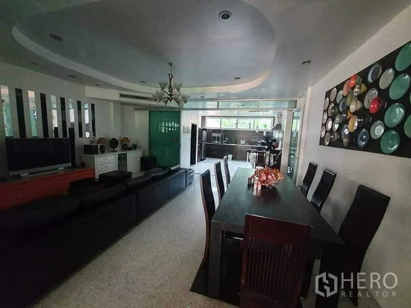 Townhouse for rent or sale in Bang Kho Laem, Bangkok - Open-plan living and dining area with long table leading to the kitchen.