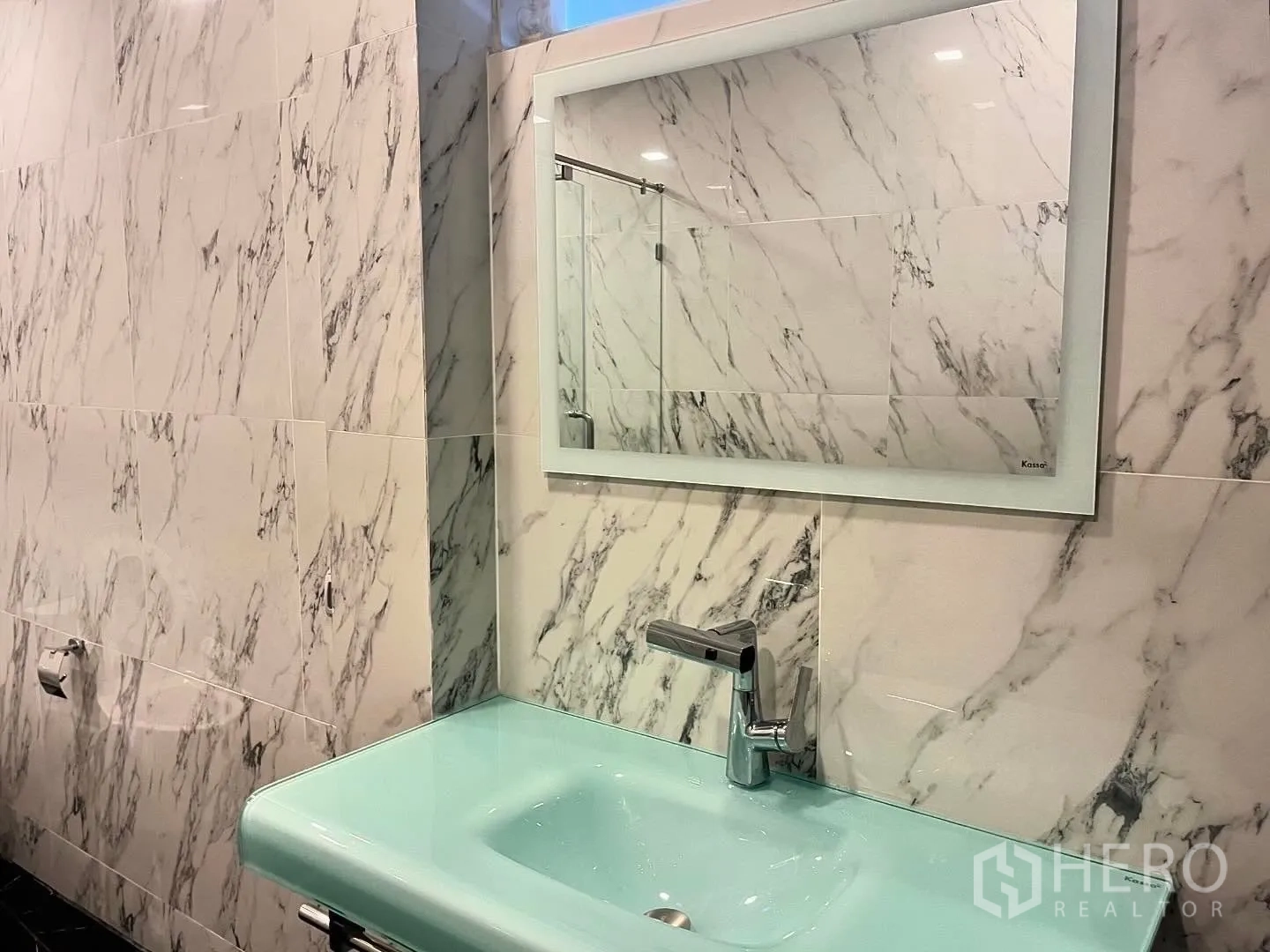Shophouse for rent in Bang Rak, Bangkok - Bathroom with marble-style wall tiles, large mirror, and mint sink.