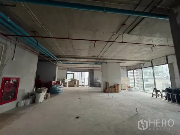 Office Space for rent in Khlong Toei, Bangkok - Spacious corner office area with fire hose cabinet and panoramic glazing over Bangkok skyline.