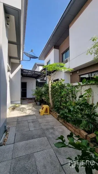 Detached House for rent or sale in Saphan Sung, Bangkok - Service yard with tiled path, side plantings and a utility canopy.