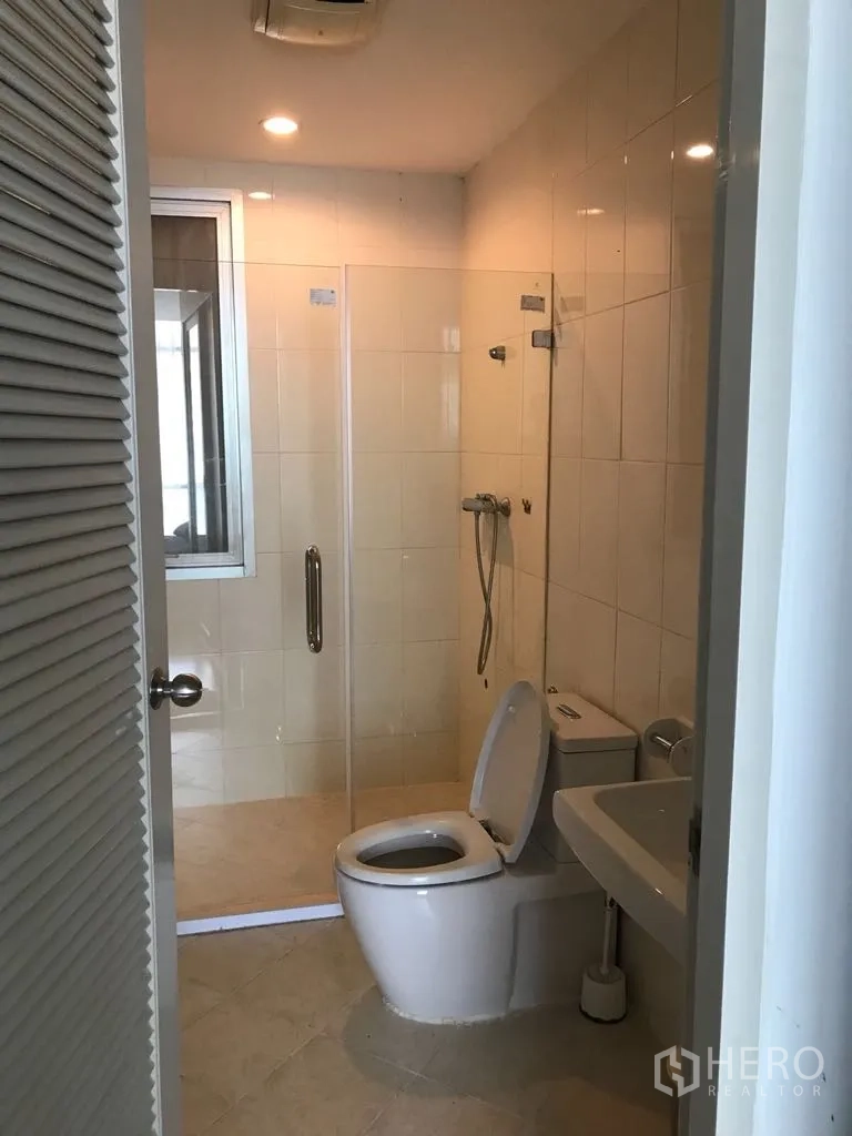 Condominium for rent in Watthana, Bangkok - Bathroom with glass-enclosed shower, toilet and vanity