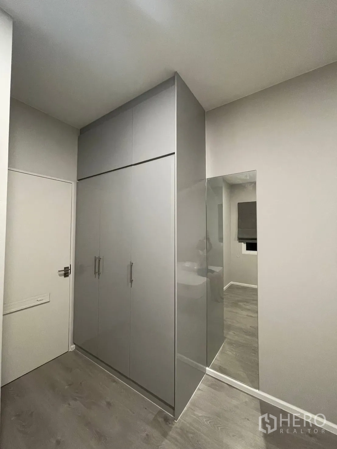 Detached House for rent in Prawet, Bangkok - Compact bedroom corner with glossy built-in wardrobe and mirror.