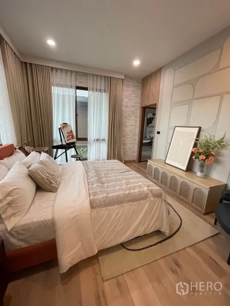 Detached House for sale in Bang Kapi, Bangkok - Cozy guest bedroom with soft lighting, custom headboard wall and console cabinet.