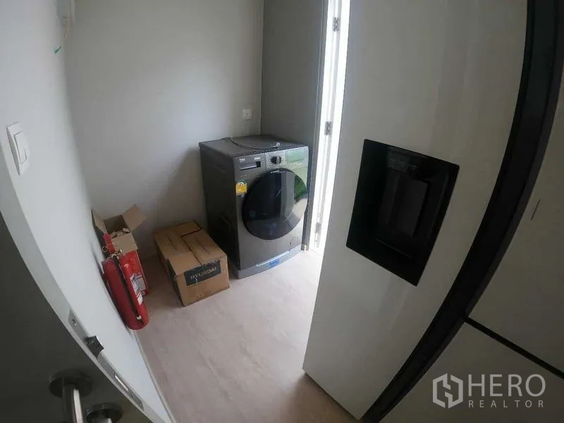 Townhouse for rent - Compact laundry room with washing machine and door opening to the side yard.