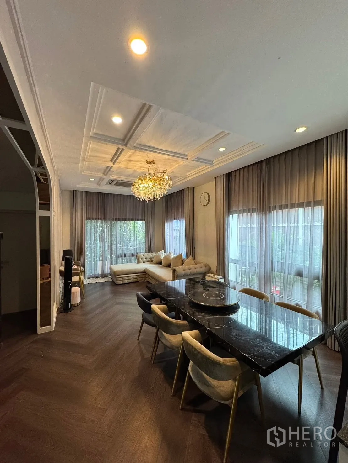 独立式住宅 出售在Mueang Pathum Thani, Pathum Thani - 餐厅与转角客厅，水晶吊灯与转角窗。