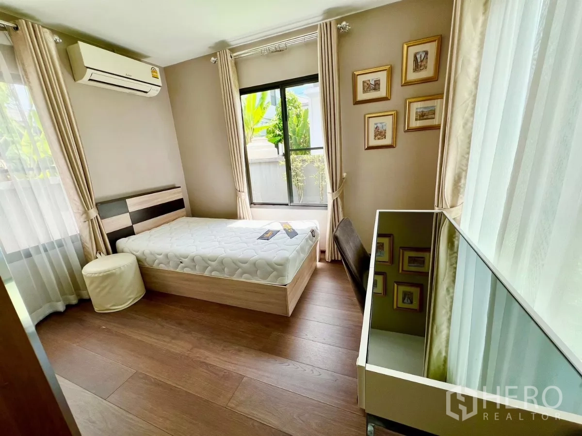 Detached House for rent or sale in Bang Phli, Samut Prakan - Bright single bedroom with air conditioning and corner windows overlooking greenery.