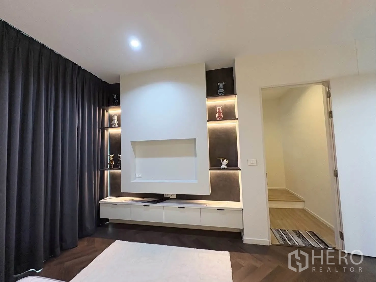 Detached House for rent in Saphan Sung, Bangkok - Built-in shelving with accent lighting beside a media wall and doorway.