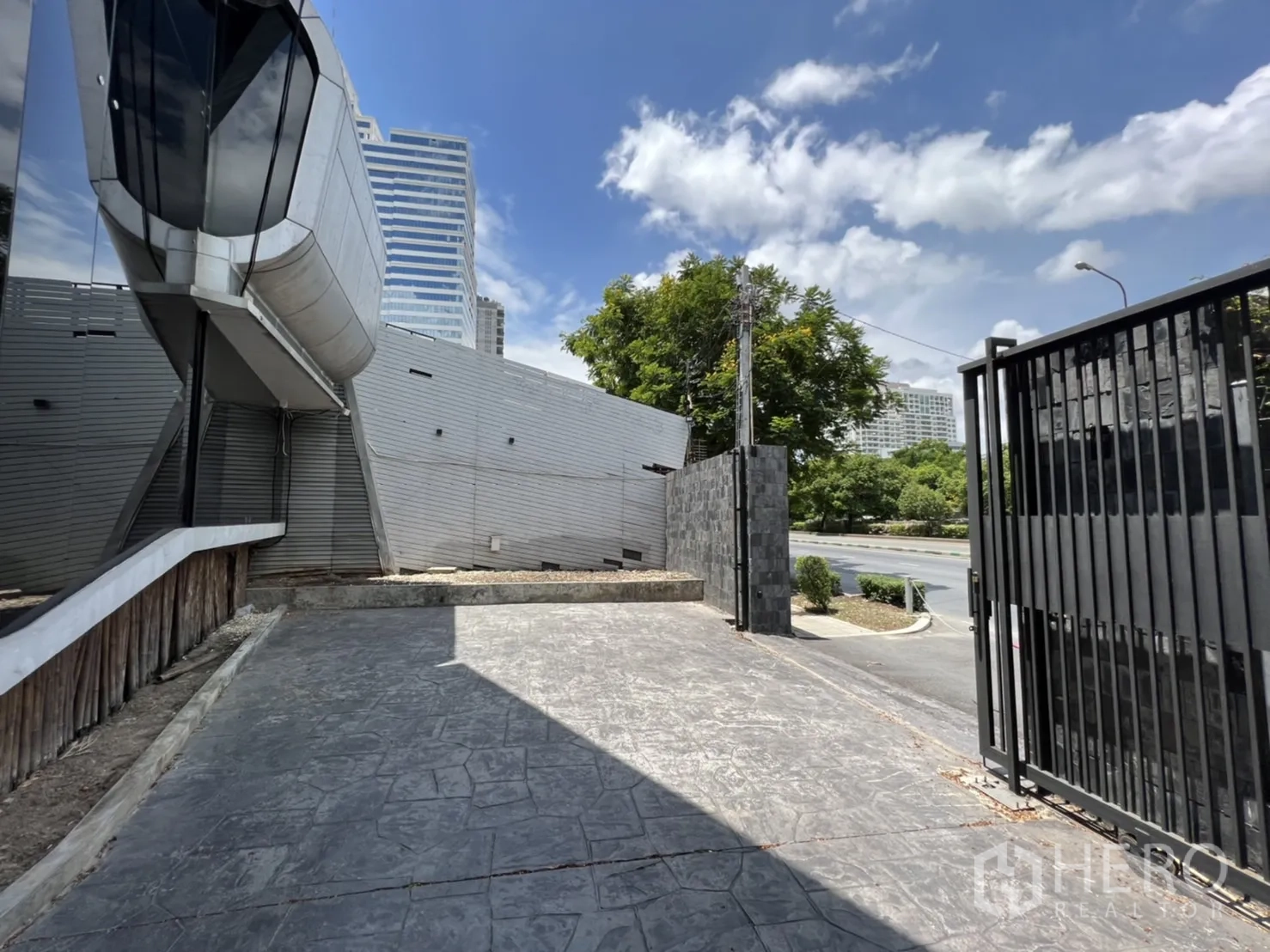 พื้นที่ขายปลีก ให้เช่าในSathon, Bangkok - ประตูรั้วและทางเข้าอาคารสมัยใหม่ เห็นวิวเมืองด้านหลัง