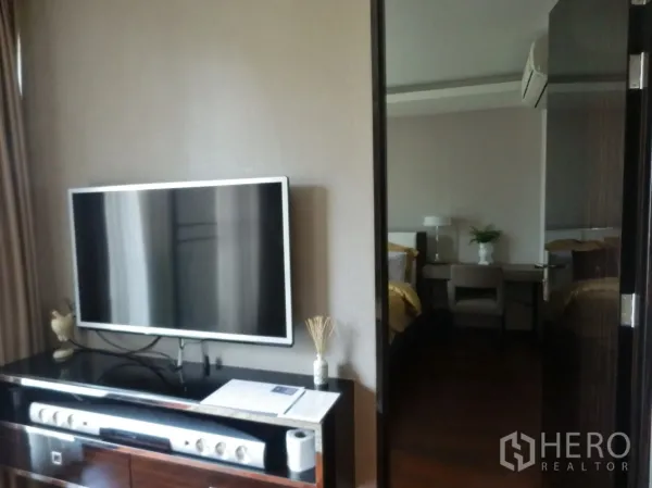 คอนโด ให้เช่าในWatthana, Bangkok - ชั้นวางทีวีพร้อมจอแบน มองผ่านประตูสู่ห้องนอน ในคอนโดสไตล์โมเดิร์น