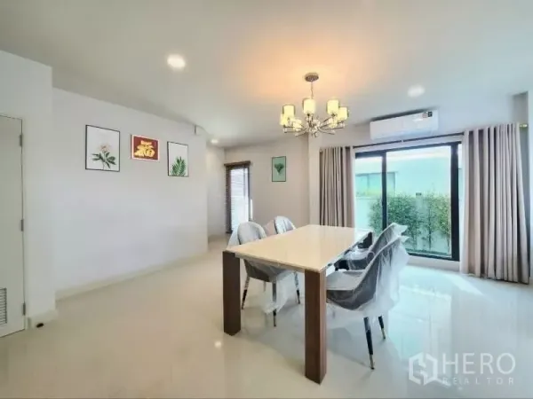 Detached House for rent in Bang Phli, Samut Prakan - Dining area with six-seat table, chandelier and sliding doors to the garden.