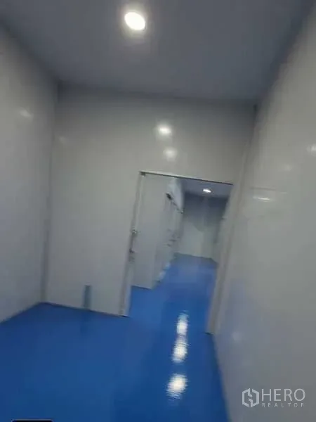 工厂 出租在Lam Luk Ka, Pathum Thani - 明亮走道，LED筒灯与多处房门，通向分隔生产区。