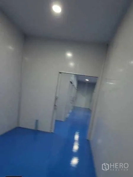 工厂 出租在Lam Luk Ka, Pathum Thani - 明亮走道，LED筒灯与多处房门，通向分隔生产区。