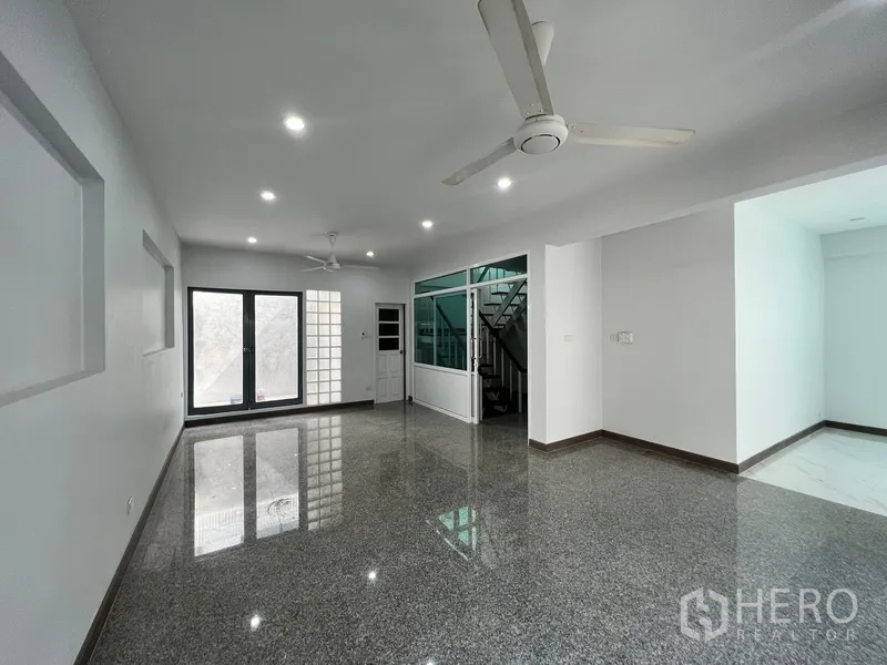 带办公室的家 出租在Watthana, Bangkok - 开放式客厅，亮面地面、吊扇与楼梯。