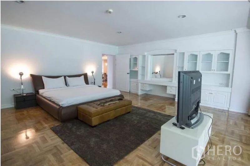 อพาร์ทเมนท์ ให้เช่าในRatchathewi, Bangkok - ห้องนอนใหญ่กว้างพร้อมตู้บิลท์อินสีขาว โต๊ะเครื่องแป้ง ที่วางทีวี และพื้นปาร์เกต์เงางาม