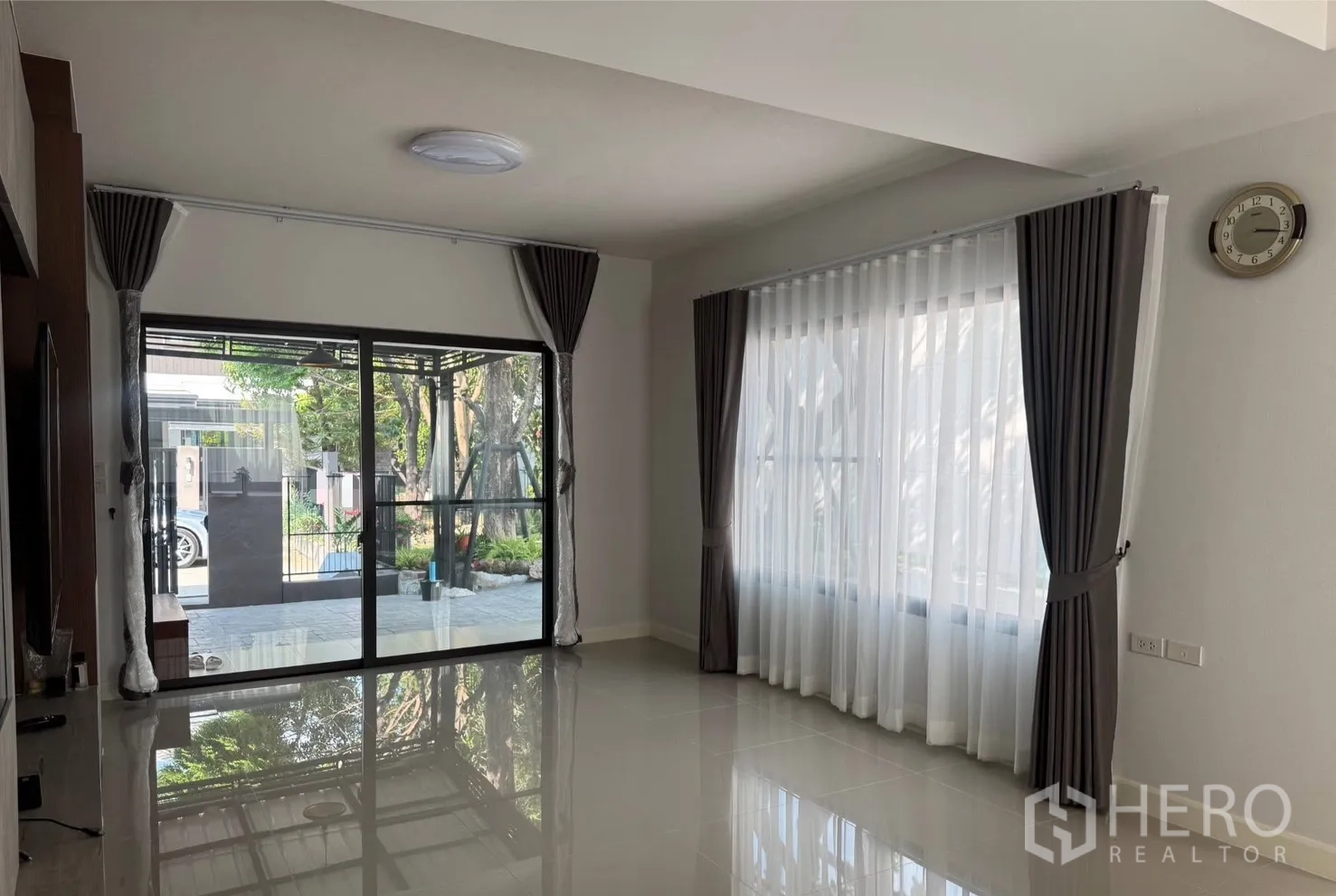บ้าน for rent in Bang Phli, Samut Prakan - ห้องนั่งเล่นสว่างด้วยผ้าม่านโปร่งและประตูกระจกออกสู่ลานหน้า