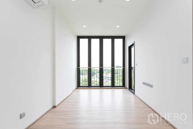 คอนโด ขายในWatthana, Bangkok - ห้องนั่งเล่นสว่าง ประตูระเบียงสูง มองเห็นวิวต้นไม้รอบโครงการ