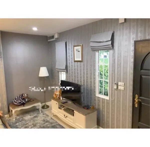 联排别墅 出租在Bang Kapi, Bangkok - 温馨客厅，电视柜、窗帘与特色墙纸。