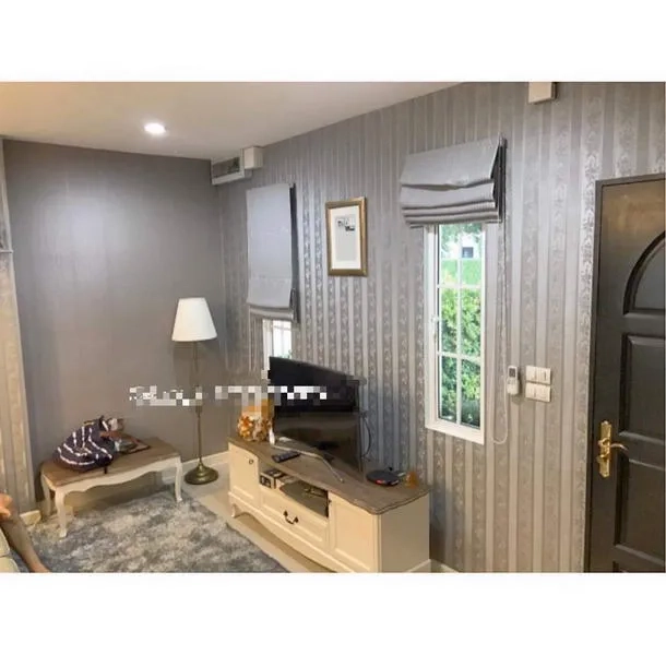 联排别墅 出租在Bang Kapi, Bangkok - 温馨客厅，电视柜、窗帘与特色墙纸。