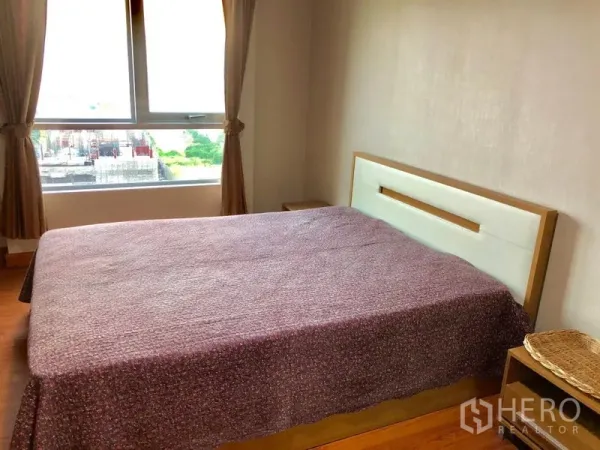 Condominium for rent in Huai Khwang, Bangkok - Bright bedroom with double bed, large window, curtains, and city view at Belle Grand Rama 9.