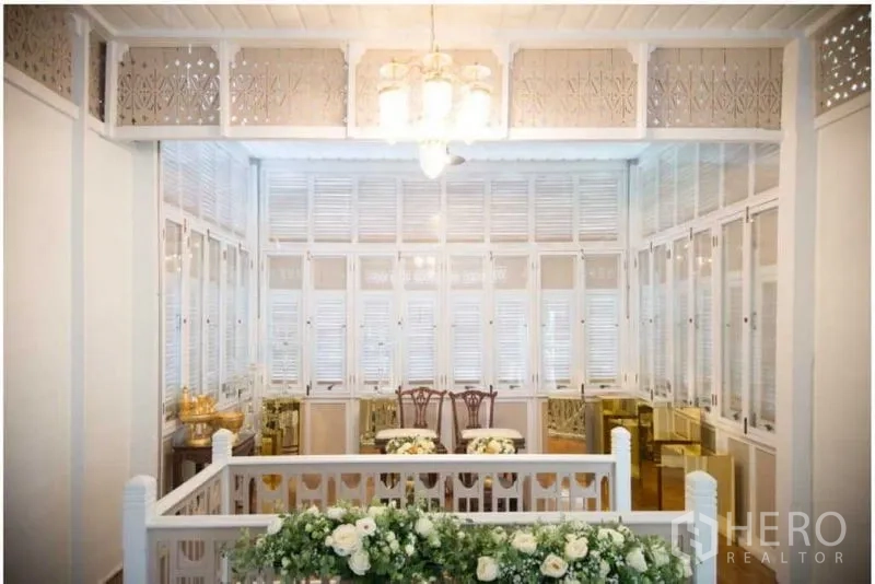 Detached House for rent in Bang Rak, Bangkok - Upstairs hall with chandelier, shuttered windows and floral decorations.