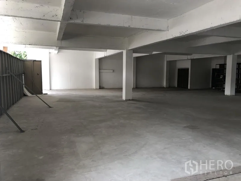 Office Space for rent in Khlong Toei, Bangkok - Wide industrial-style office area with support columns and a partial metal partition.