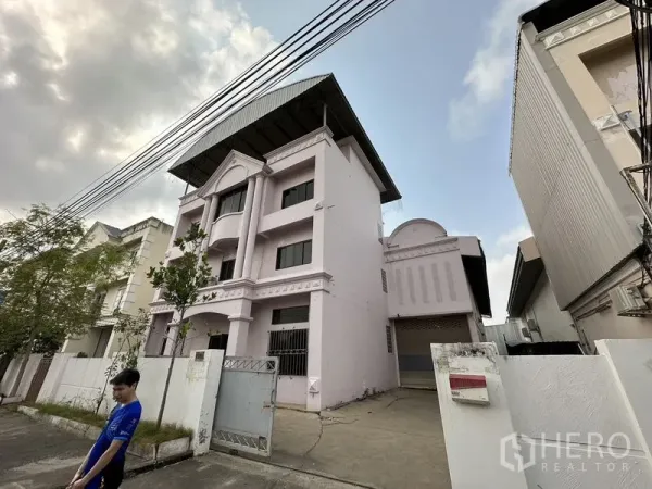 工厂 出租在Bang Bua Thong, Nonthaburi - 粉色厂房侧视图，前门与车道通往装卸区，Bang Bua Thong