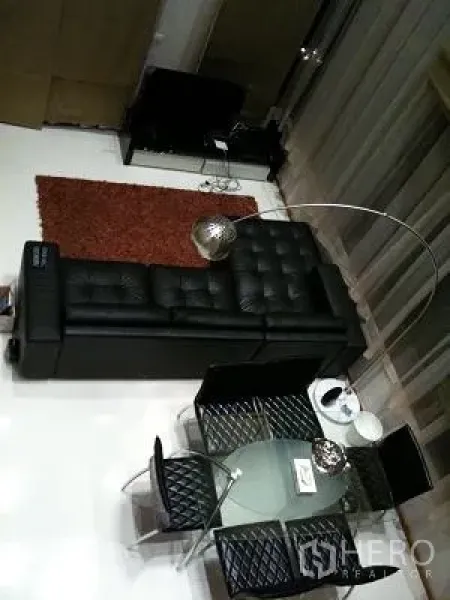 公寓 出租或出售在Khlong Toei, Bangkok - 俯视开放式客餐区，玻璃餐桌与现代沙发和地毯。