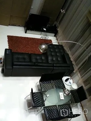 公寓 出租或出售在Khlong Toei, Bangkok - 俯视开放式客餐区，玻璃餐桌与现代沙发和地毯。