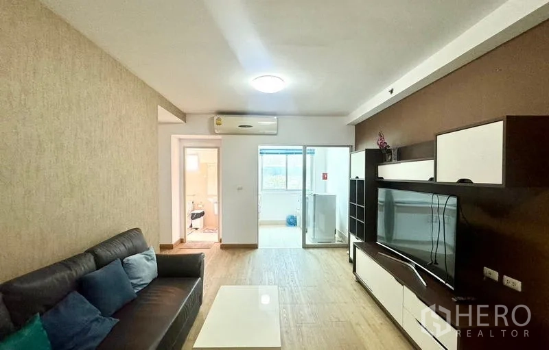 คอนโด ให้เช่าในHuai Khwang, Bangkok - มุมห้องนั่งเล่นพร้อมชั้นวางทีวีบิวต์อินและประตูกระจกบานเลื่อนออกไประเบียง