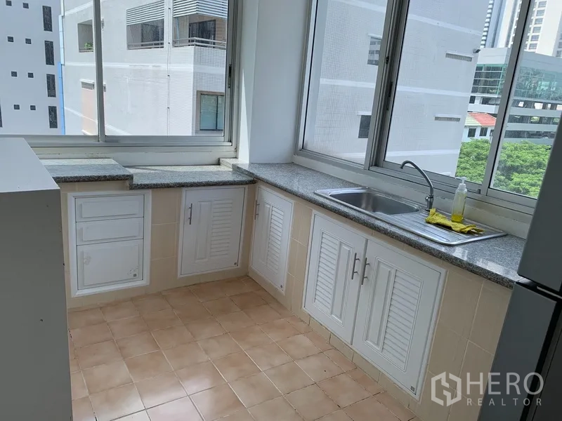 公寓 出租在Sathon, Bangkok - 独立厨房，花岗岩台面、白色橱柜与大窗。