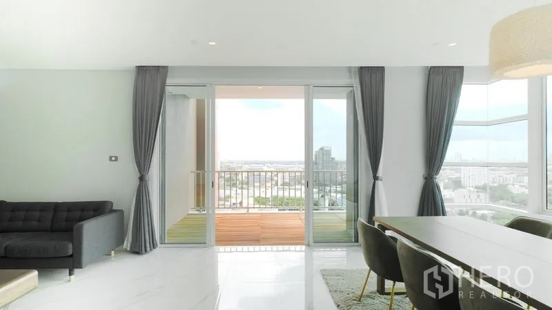 คอนโด ขาย - พื้นที่นั่งเล่นประตูกระจกบานเลื่อนออกสู่ระเบียง วิวเมืองพาโนรามา