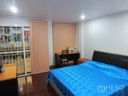 Home Office for rent or sale in Wang Thonglang, Bangkok - Bedroom with large bed, desk and sliding door to balcony.