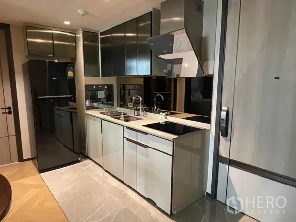 Condominium for rent - Modern galley kitchen with built-in cabinets, electric hob, hood and full-size refrigerator.