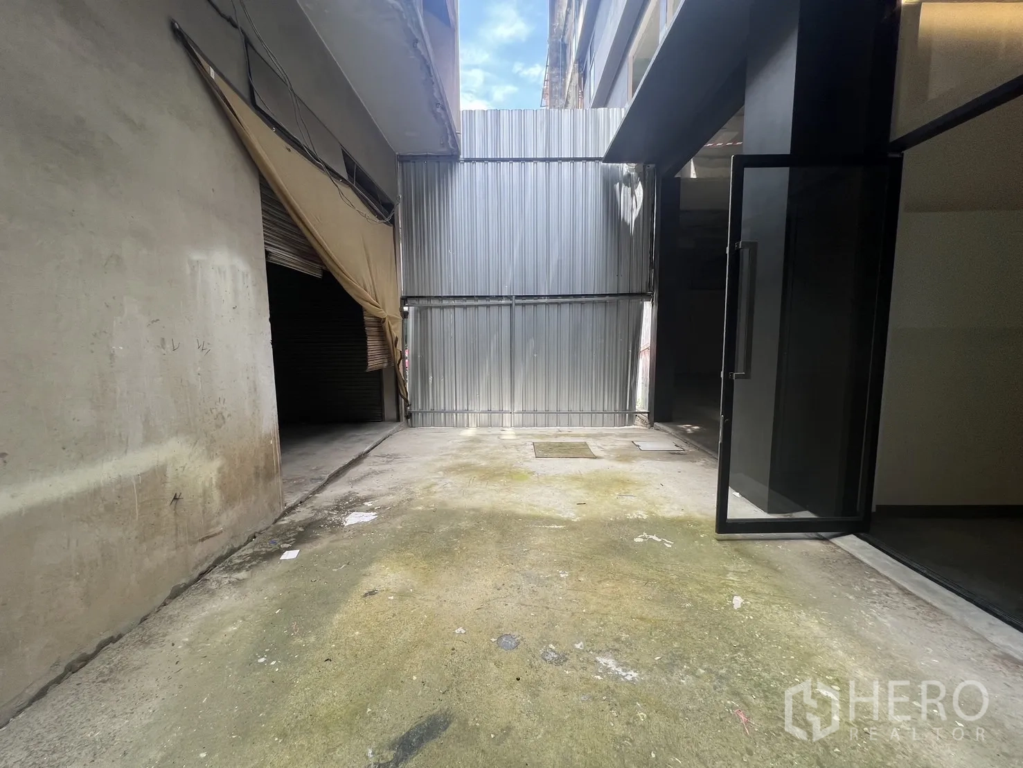 店屋 for rent in Bang Rak, Bangkok - 带金属门的入口小院，旁边为玻璃门与毛坯墙面。
