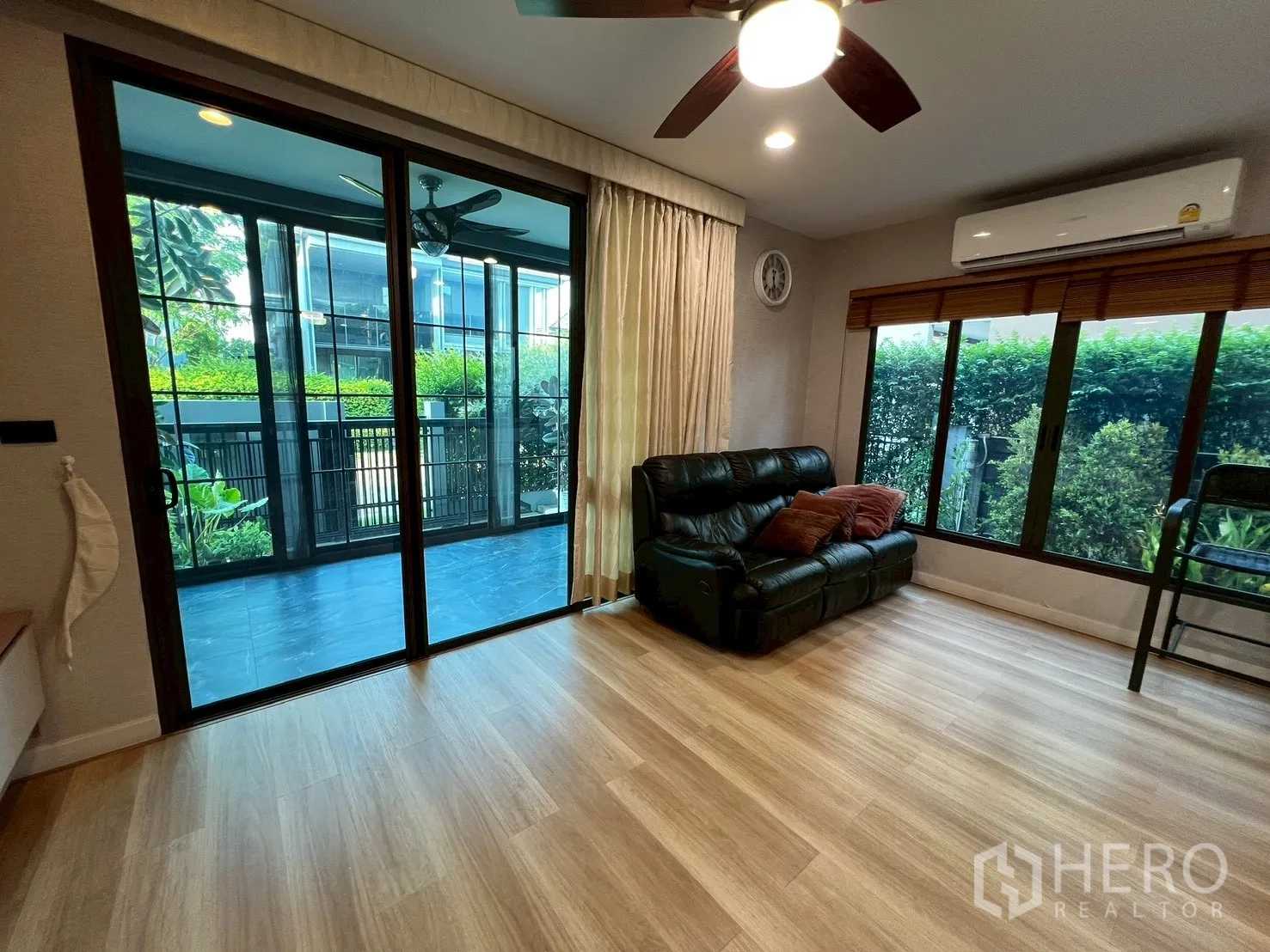 独栋房屋 for rent in Bang Kapi, Bangkok - 客厅设推拉门通向有顶露台与绿篱花园。