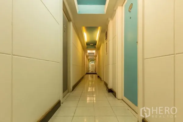 店屋 出租在Phaya Thai, Bangkok - 明亮走廊，瓷砖地面与蓝色房门通向各房间。