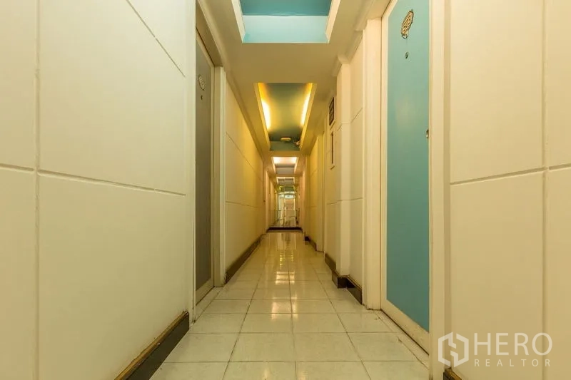店屋 出租在Phaya Thai, Bangkok - 明亮走廊，瓷砖地面与蓝色房门通向各房间。