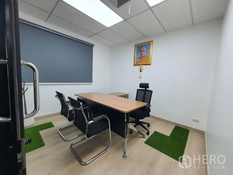 办公空间 出租 - 独立经理室，办公桌、会客椅、卷帘与小块绿色地毯点缀。
