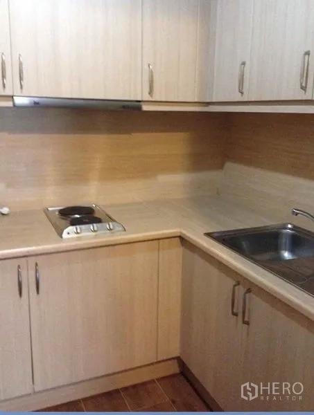 คอนโด ให้เช่าในKhlong Toei, Bangkok - ครัวรูปตัวแอลพร้อมเตาไฟฟ้า อ่างล้างจาน และตู้เก็บของลายไม้