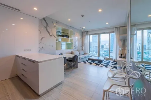 公寓 出租在Pathum Wan, Bangkok - 宽敞开放式起居区，岛台、壁柜、推拉门通阳台与镜面墙。
