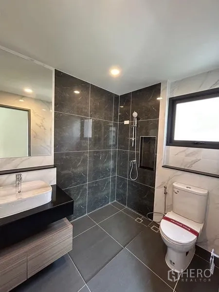 Detached House for rent - Modern bathroom with dark feature wall, walk-in shower, and WC.
