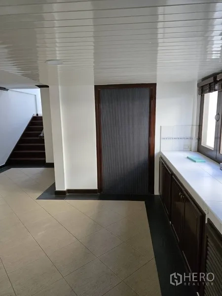 บ้าน ให้เช่าในWatthana, Bangkok - โถงครัวข้างบันไดพร้อมประตูบานเลื่อนไม้ระแนงและเคาน์เตอร์