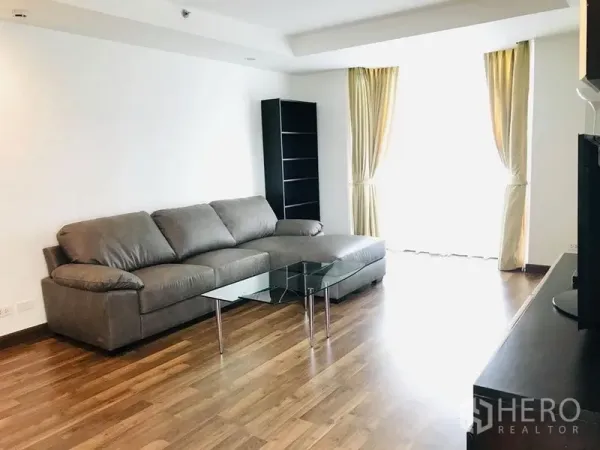 คอนโด ให้เช่าในPathum Wan, Bangkok - โซนพักผ่อนกว้าง โซฟาหนังสีเทา โต๊ะกลางกระจก และผ้าม่านสูงโปร่ง