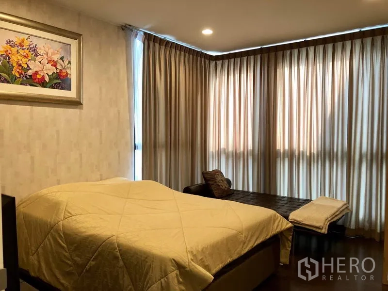 Detached House for rent or sale in Bang Kapi, Bangkok - Cozy bedroom with corner windows, full curtains and warm lighting.