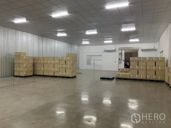 คลังสินค้า ให้เช่าในYan Nawa, Bangkok - มุมมองสู่โกดังโล่ง หน้าห้องออฟฟิศกระจก ผนังเมทัลชีท และพื้นคอนกรีต