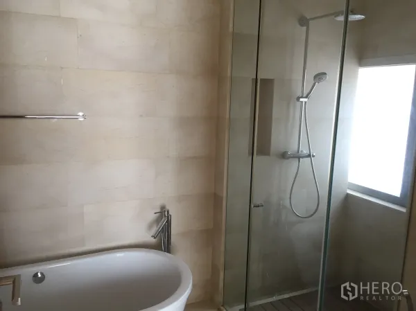 公寓 出租在Bang Rak, Bangkok - 现代卫浴，玻璃淋浴房与独立浴缸，石质墙面。