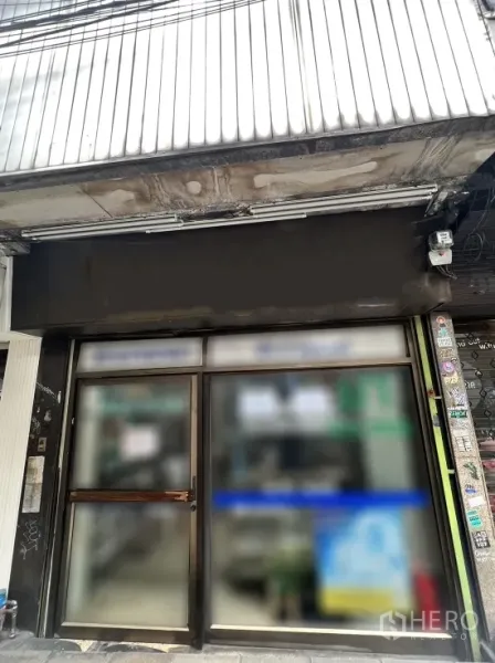 店屋 出售在Watthana, Bangkok - 临街商铺外立面，金属雨棚、监控摄像头与玻璃双开门